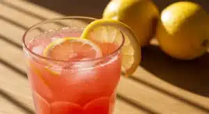 pink salt weight loss drink with lemon garnish on wooden table